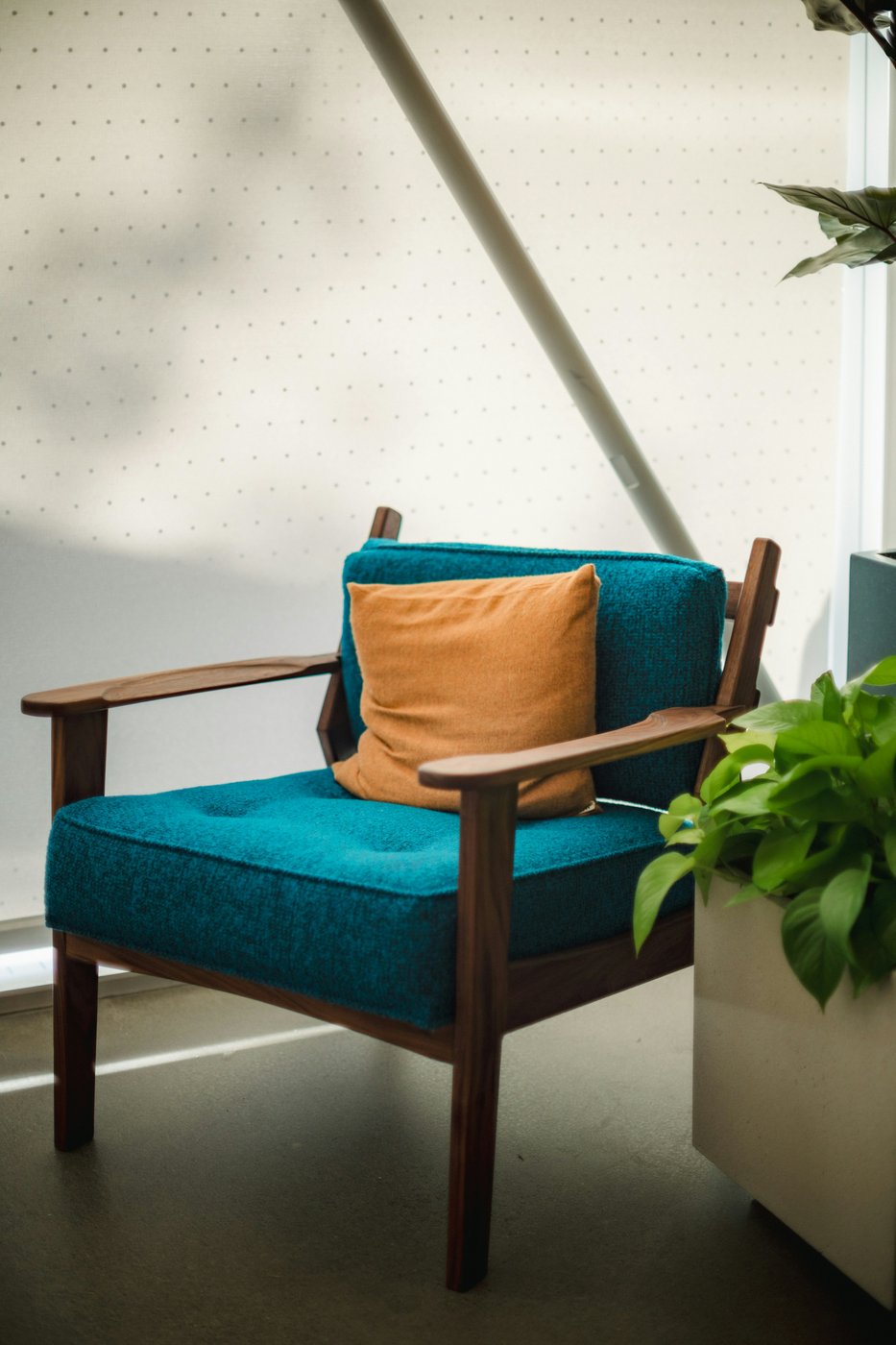 A quiet blue armchair by a sunlit window, waiting