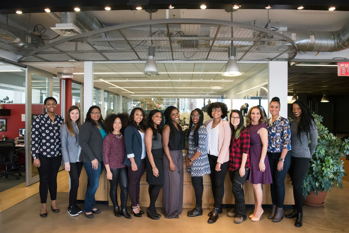 A team standing together, smiling, in a bright modern office