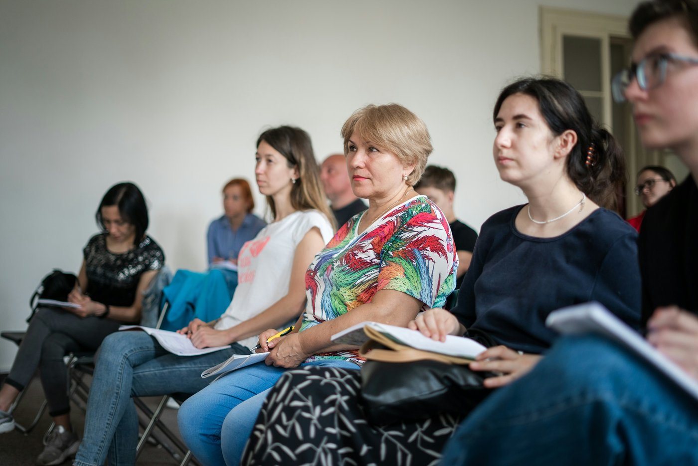 People in a workshop listening closely, taking in the room